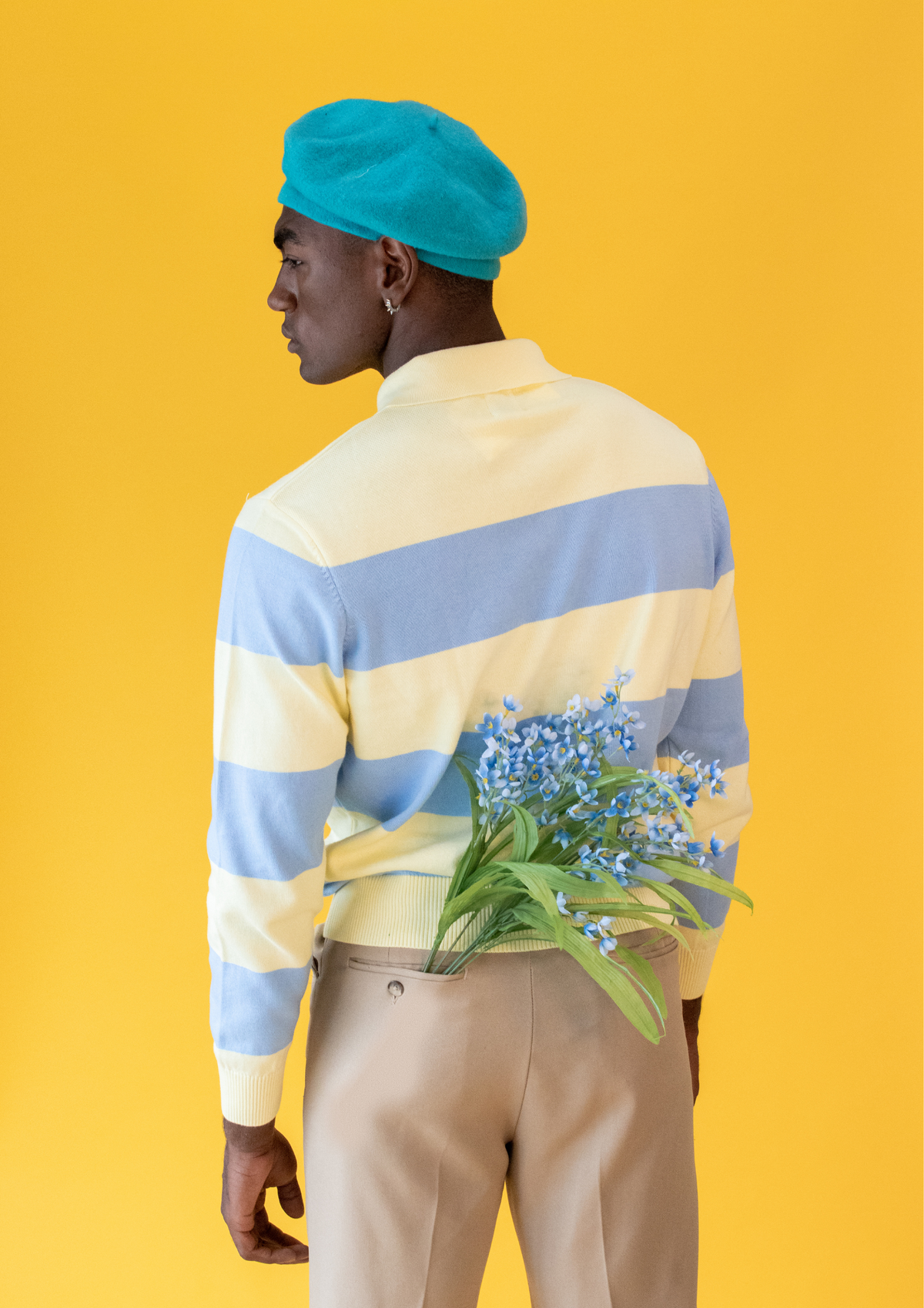 young man posing against yellow backdrop