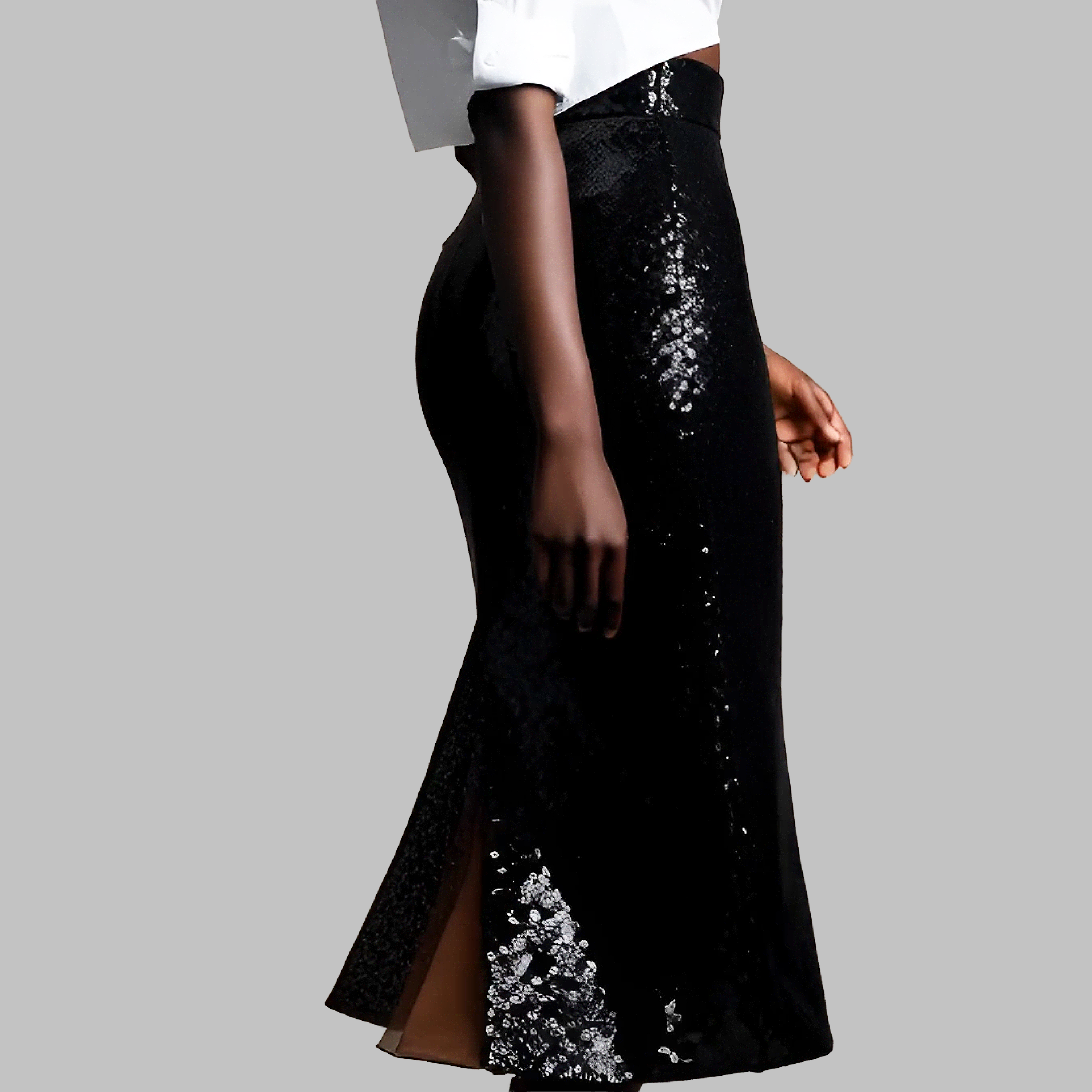 Black sequin skirt with a white top on a gray background