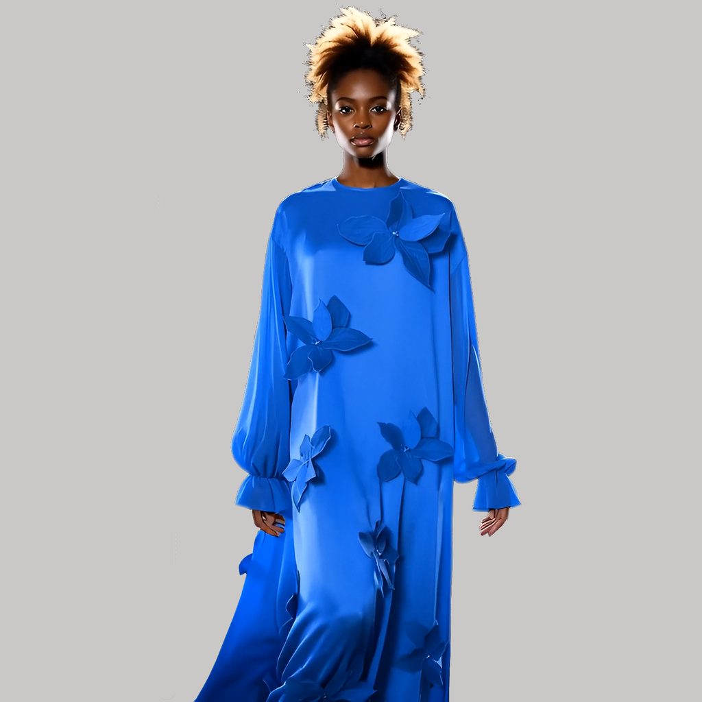 Woman wearing a blue dress with floral embellishments on a gray background