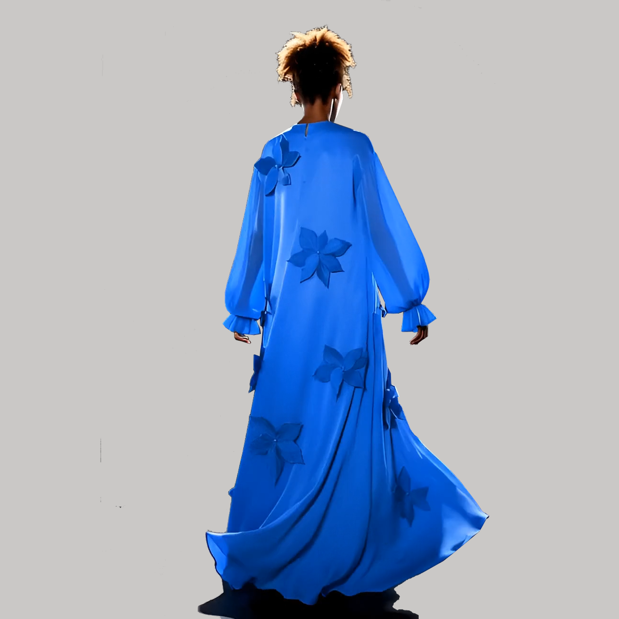 Person wearing a long blue dress with floral patterns on a gray background