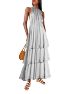 Woman wearing a WHITE tiered dress with a straw bag on a white background