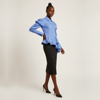 Woman wearing a blue ruffled blouse and black skirt on a white background