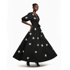 Woman wearing a black dress with white floral patterns on a white background