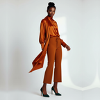 Woman wearing a rust-colored outfit with a long duster on a white background