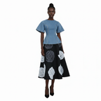Woman wearing a blue top and black skirt with white patterns on a white background