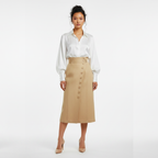 Woman wearing a white blouse and beige skirt on a white background