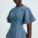 Blue denim dress worn by a model on a light gray background
