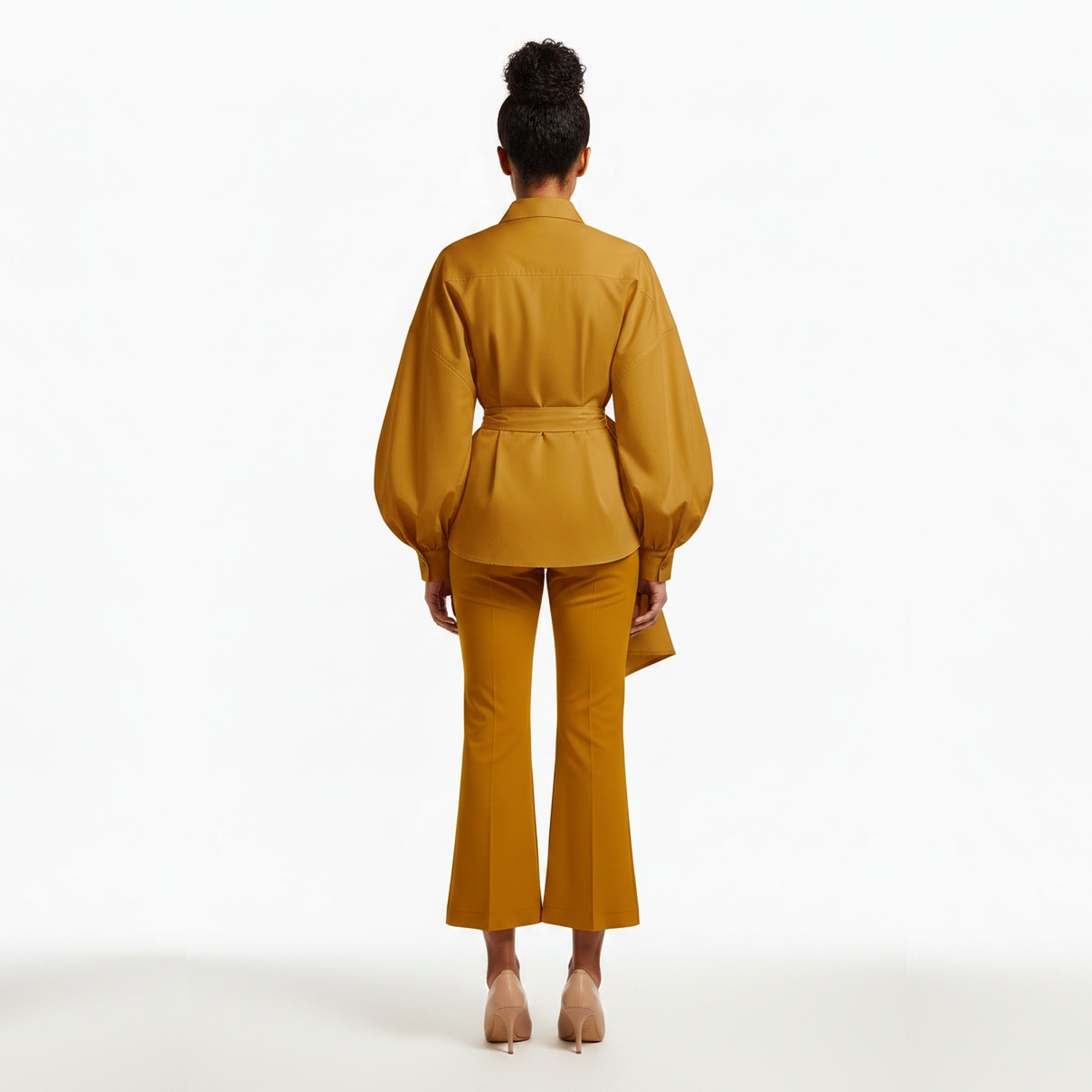 Woman wearing a mustard yellow outfit on a white background