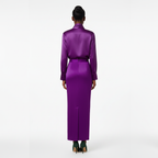 Person wearing a long purple dress on a white background