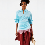 Woman wearing a light blue top and red pants on a white background