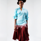 Woman wearing a light blue top and red skirt on a white background