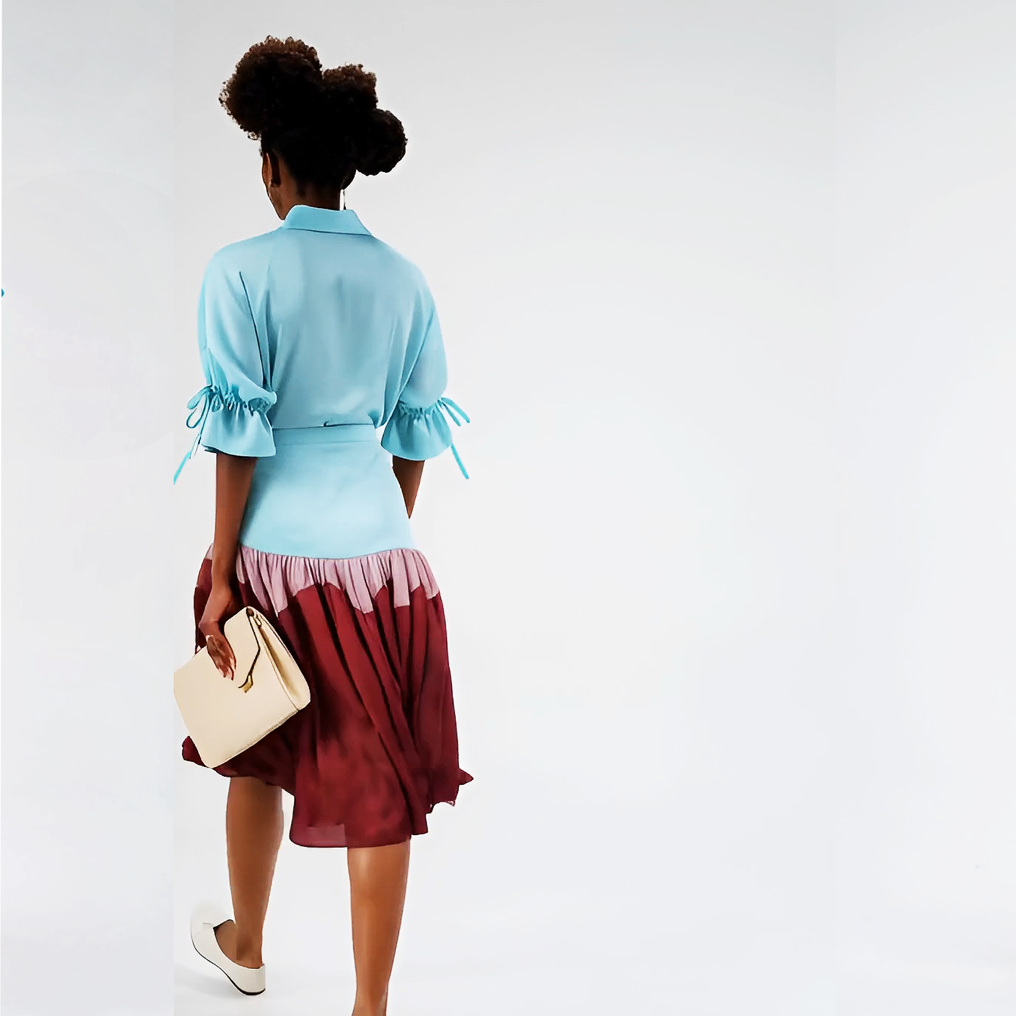 Woman wearing a blue top and red skirt with a white background