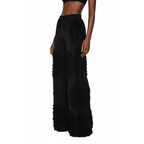 Black ruffled pants worn by a model on a white background