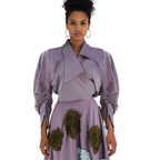 Woman wearing a purple outfit with floral details on a white background