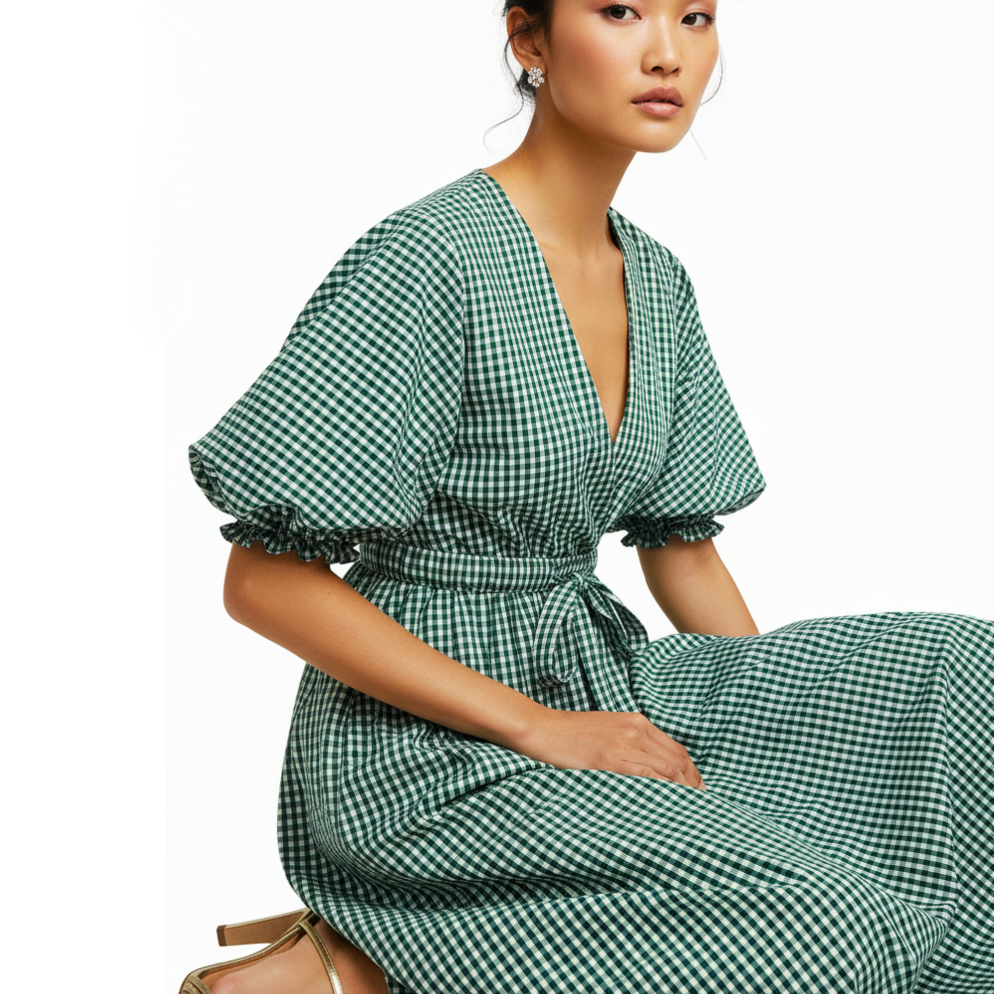 Woman wearing a green checkered dress on a white background