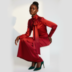 Woman wearing a red outfit with a large bow tie on a white background