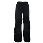 Black pants with frayed edges on a white background