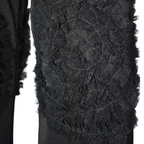Close-up of a textured black fabric with intricate patterns on a white background