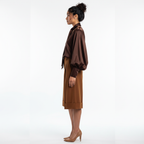 Woman wearing a brown coat and skirt on a white background