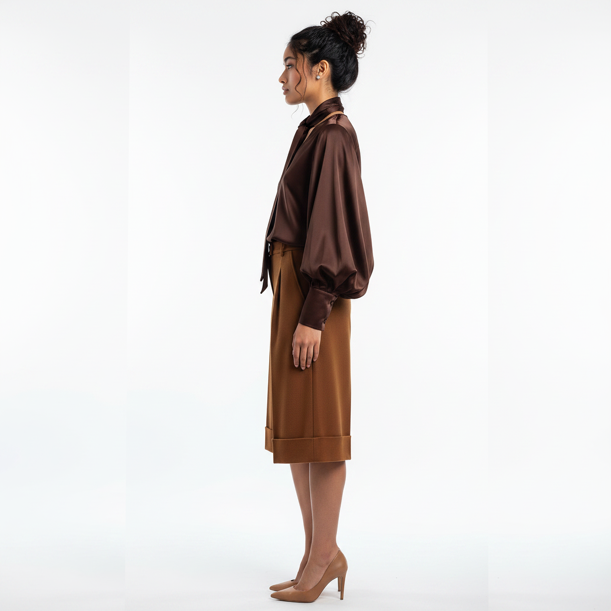 Woman wearing a brown coat and skirt on a white background