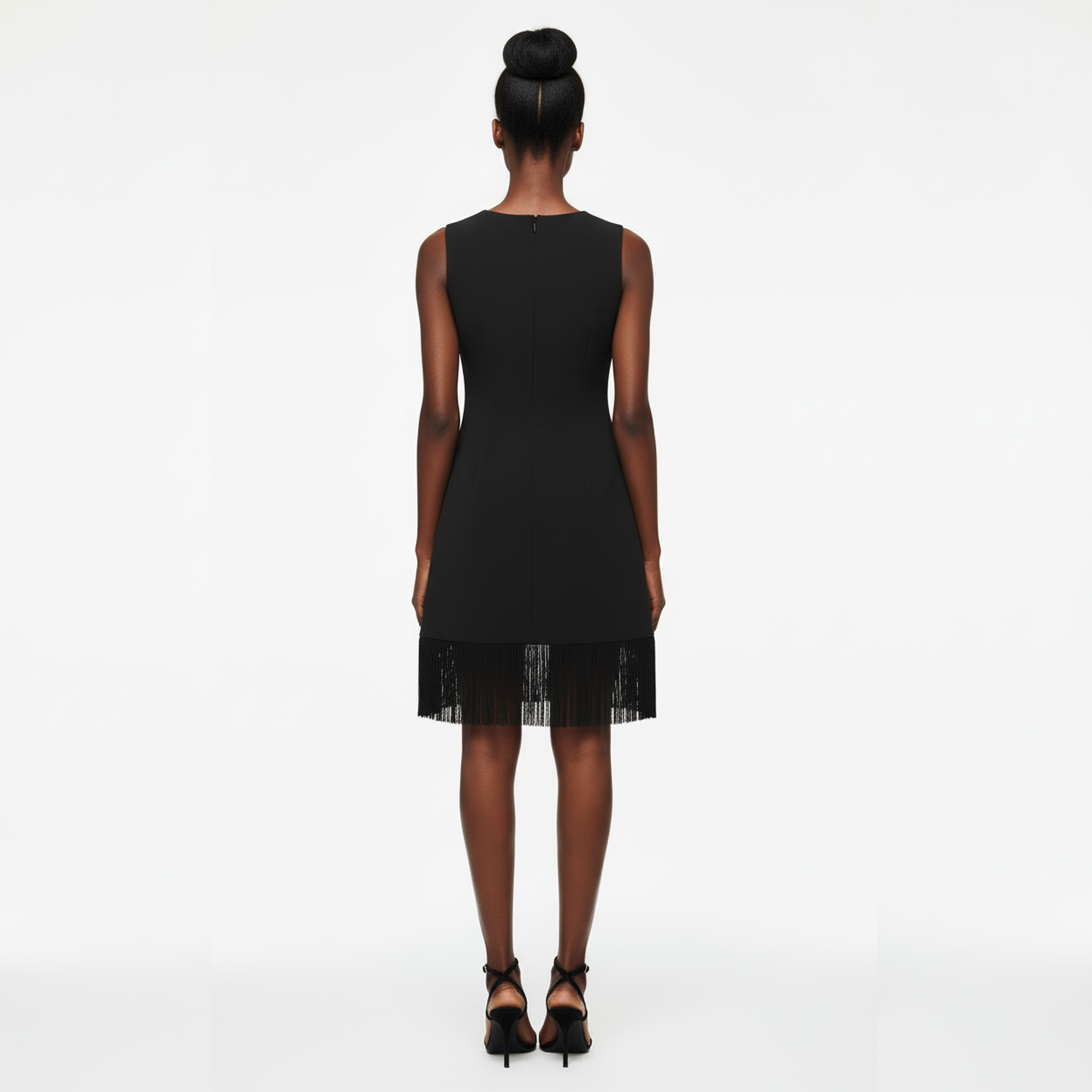 Woman wearing a black dress with sheer lace trim on a white background