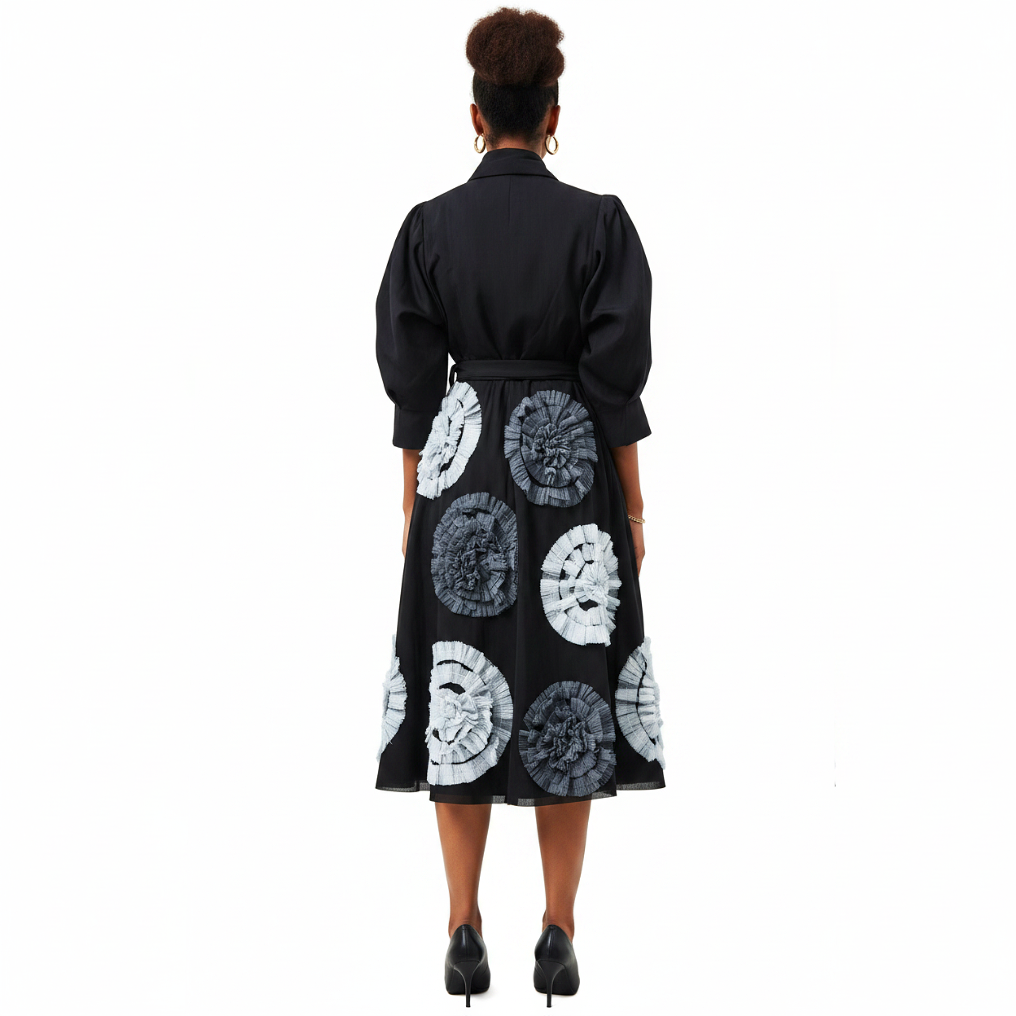 Black dress with white circular patterns worn by a person on a white background