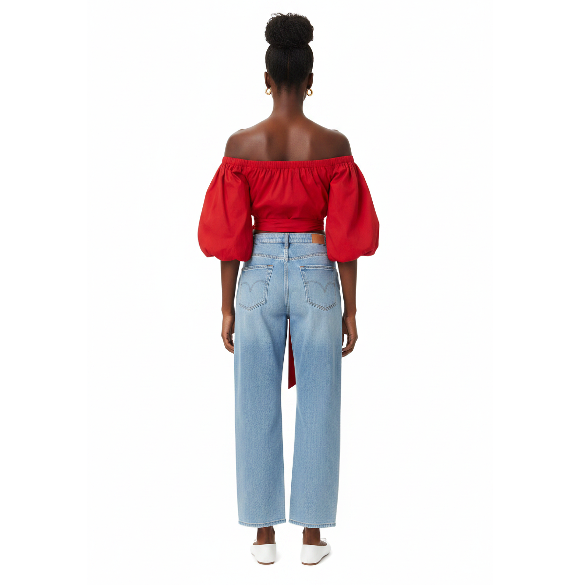 Woman wearing a red off-shoulder top with a blue jeans on a white background