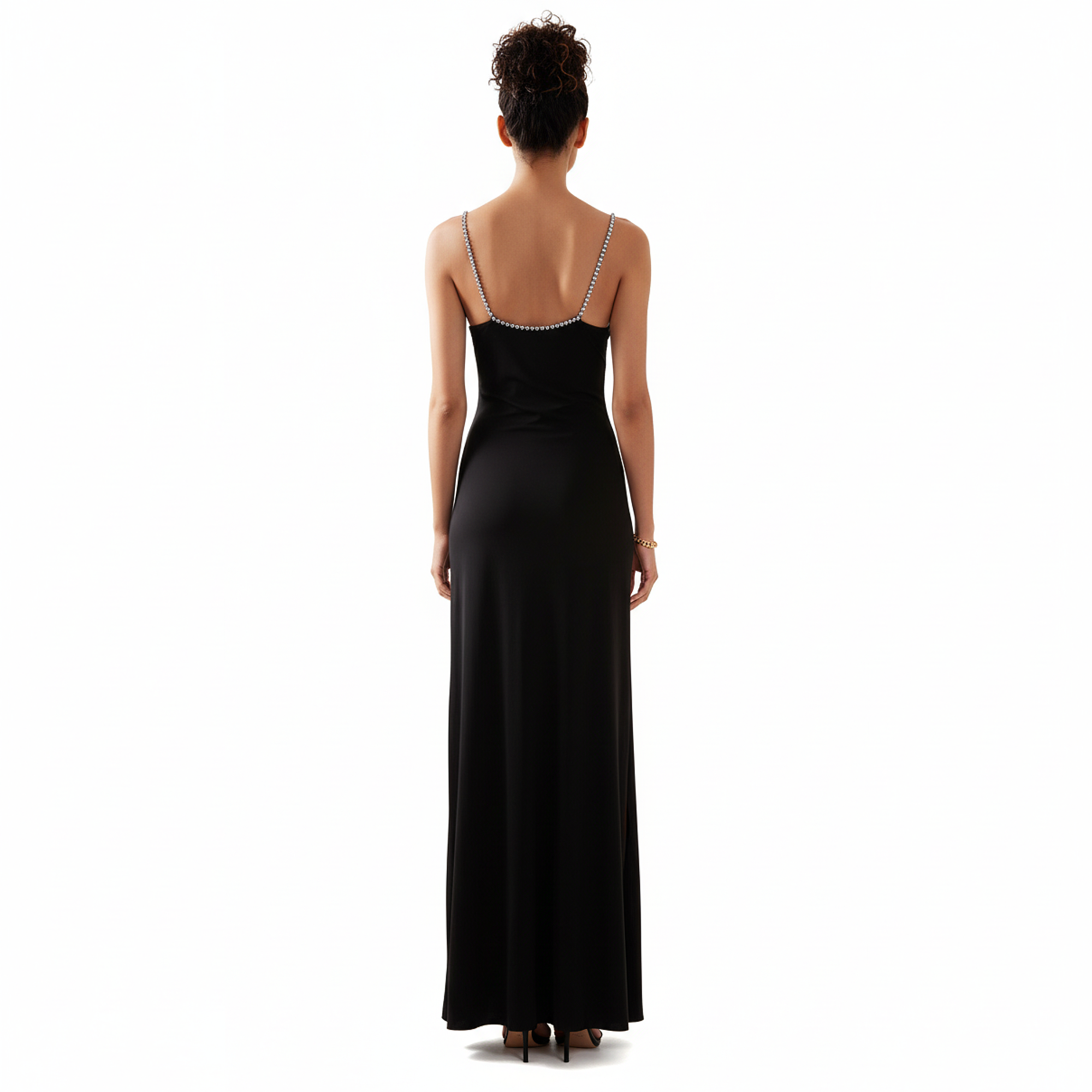 Woman wearing a black evening gown with thin straps on a white background