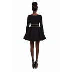Black dress with long sleeves and embellishments on a white background