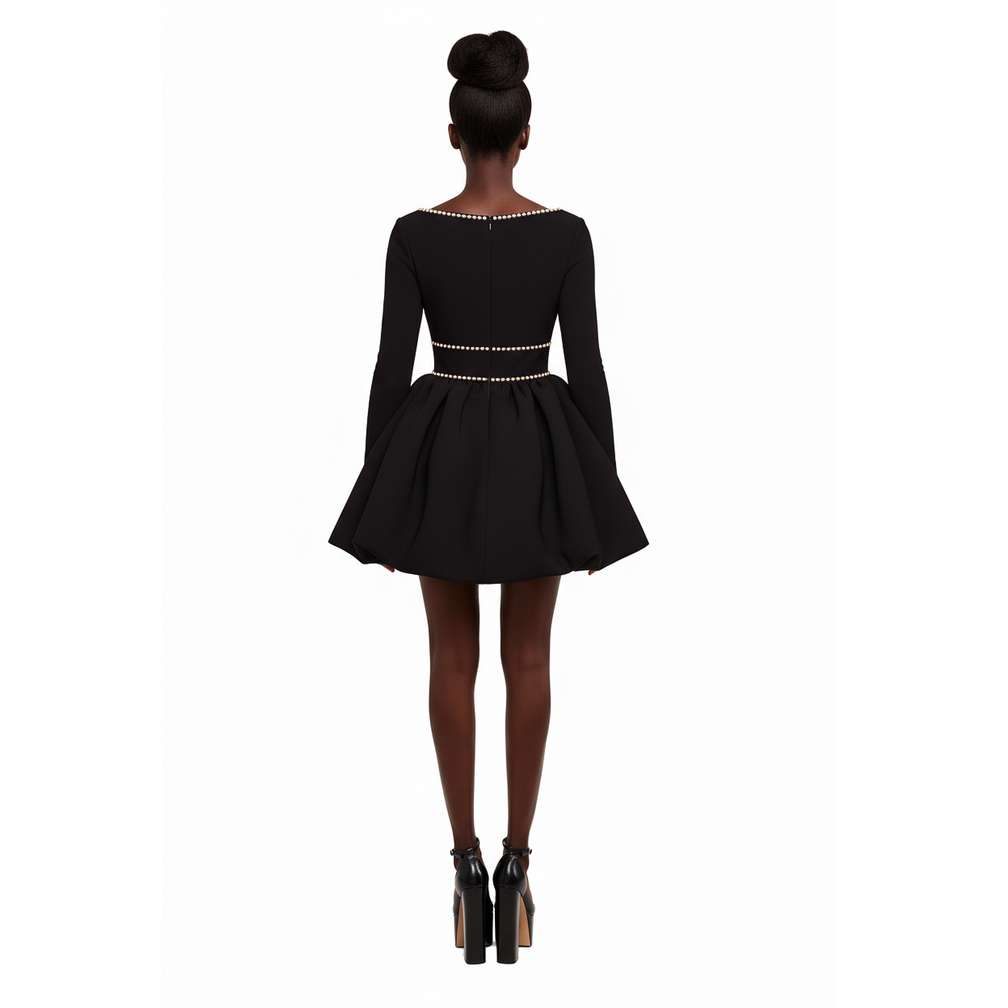 Black dress with long sleeves and embellishments on a white background