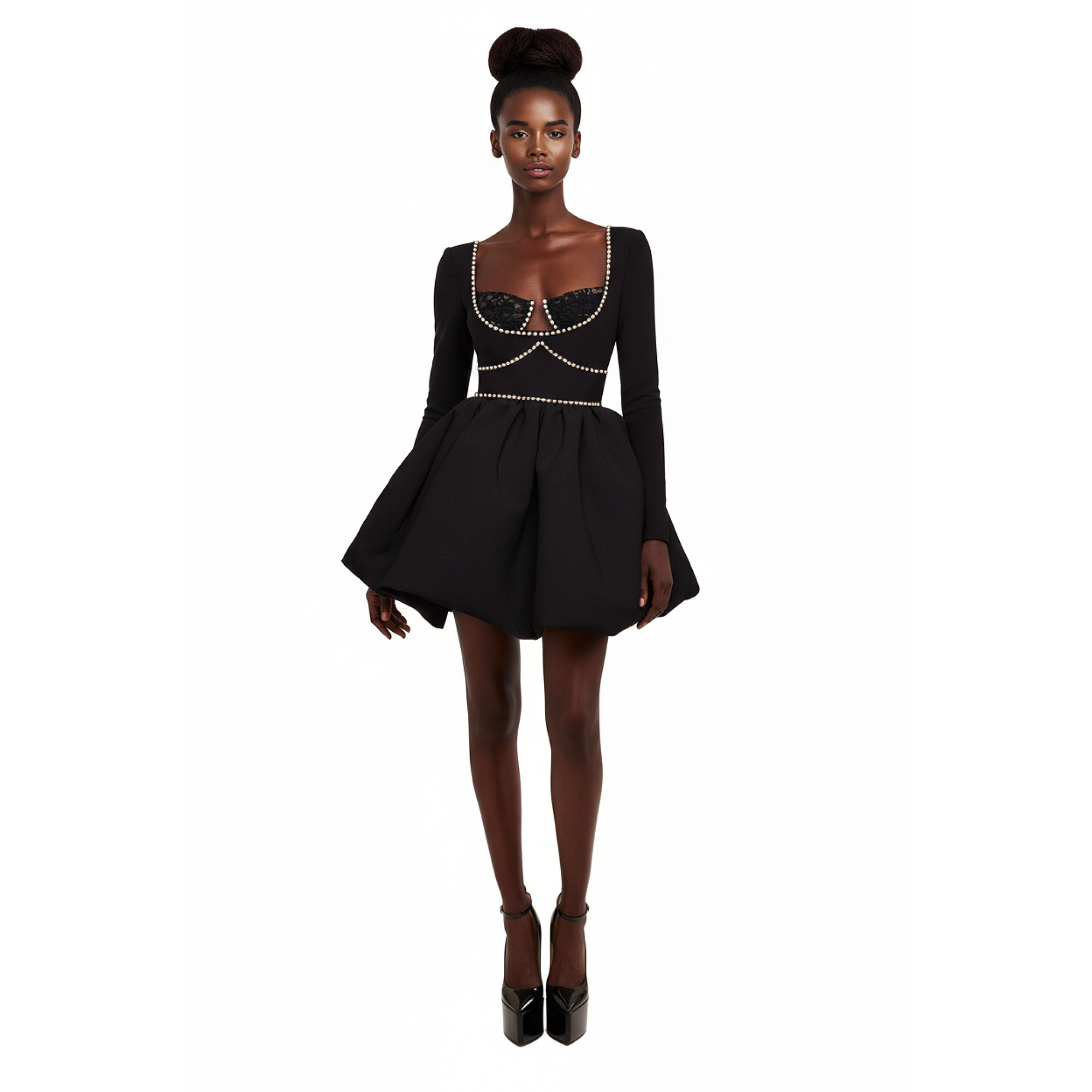 Woman wearing a black dress with intricate detailing on a white background