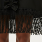 Black fringe skirt with a bow detail on a white background
