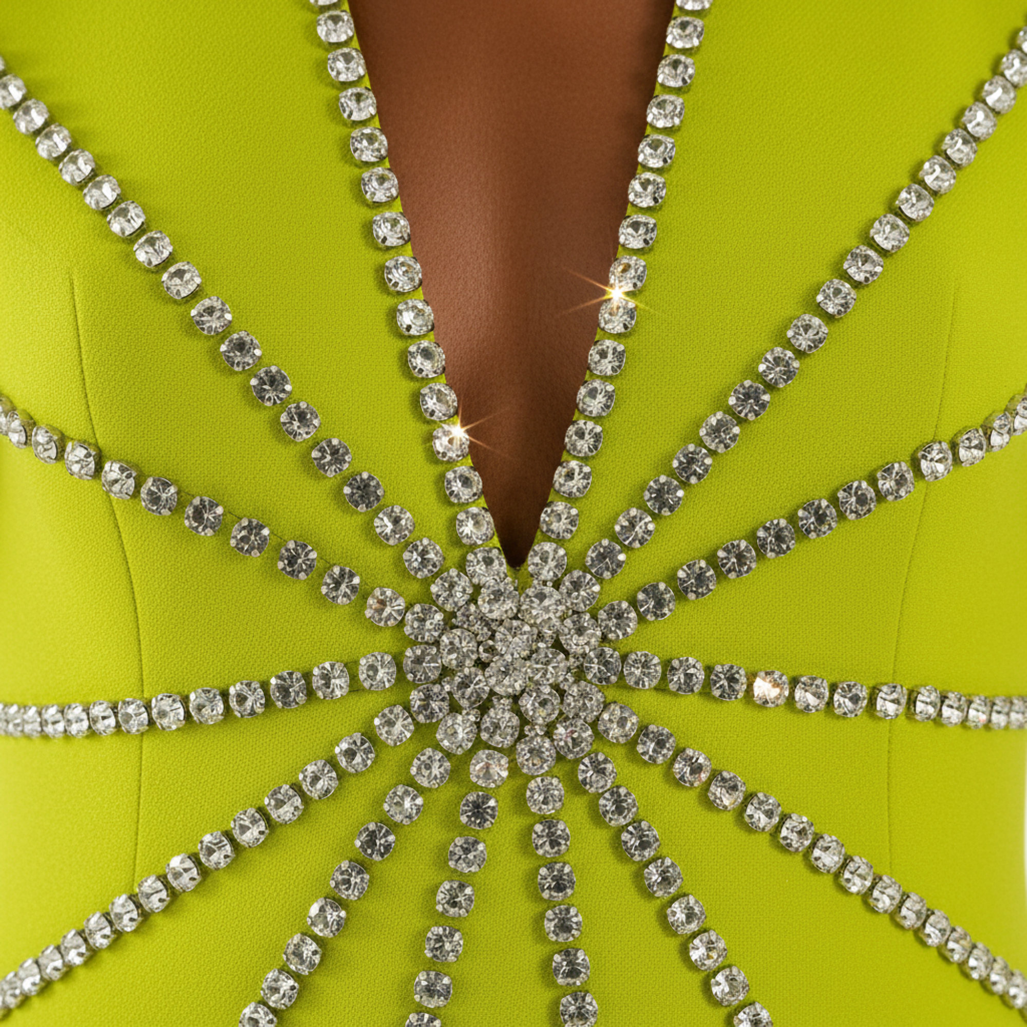 Close-up of a lime green dress with a starburst pattern of rhinestones.