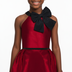 A girl wearing a wine red dress with black bow on a white background