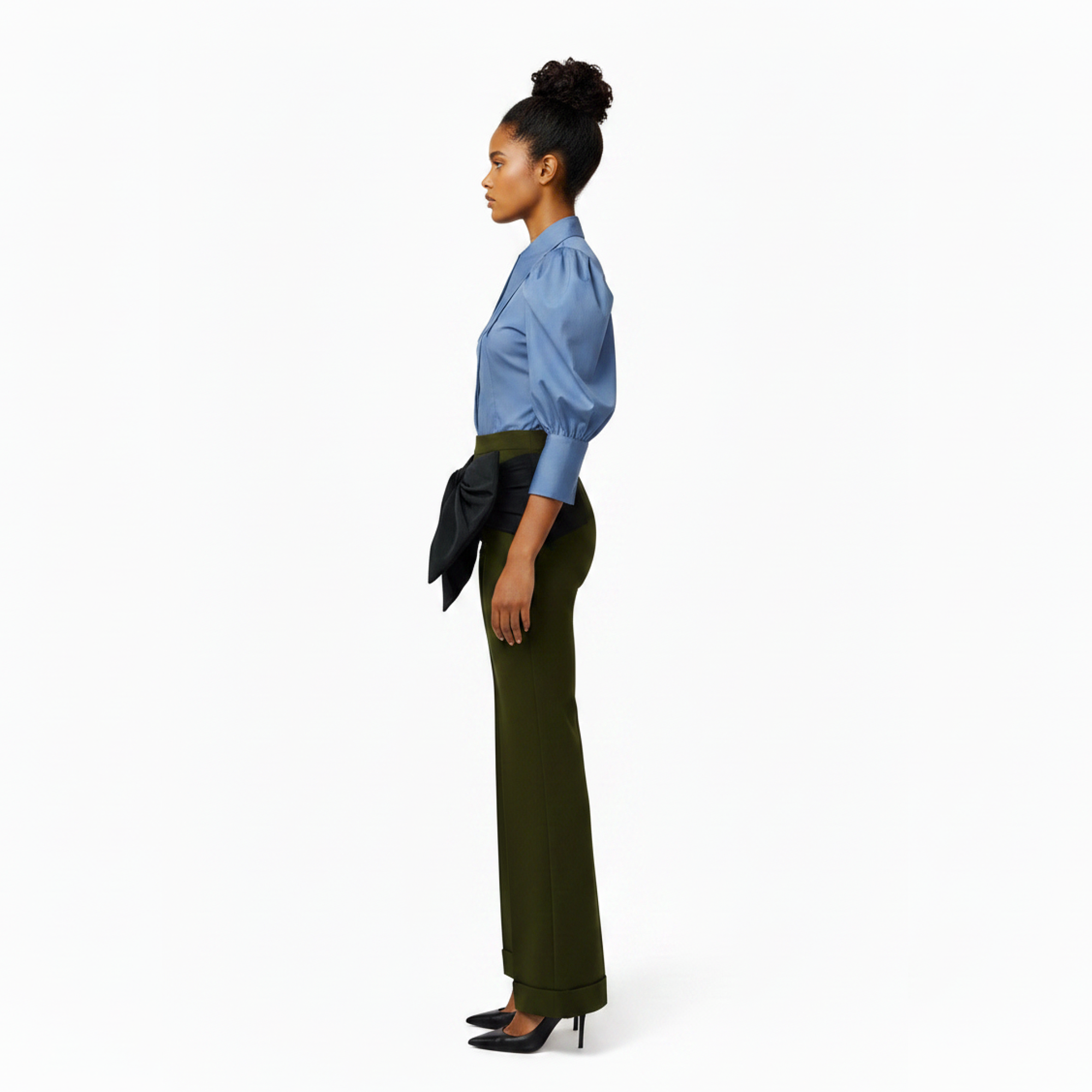 Woman wearing a blue blouse and green pants on a white background