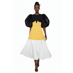 Woman wearing a dress with black, yellow, and white color block design on a white background