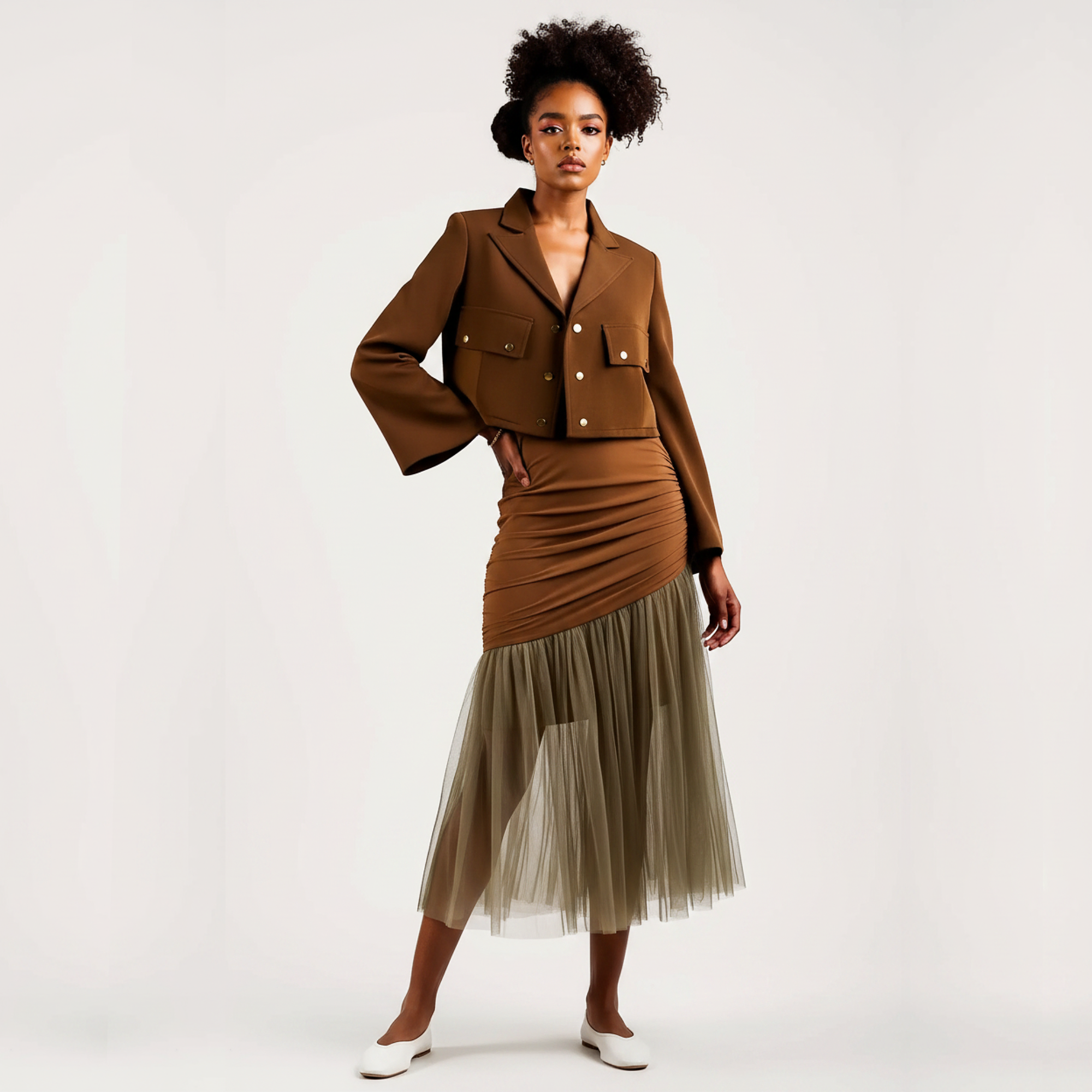 Woman wearing a brown jacket and skirt with a beige tulle hem on a white background