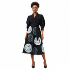 Woman wearing a black dress with white and gray circular patterns on a white background