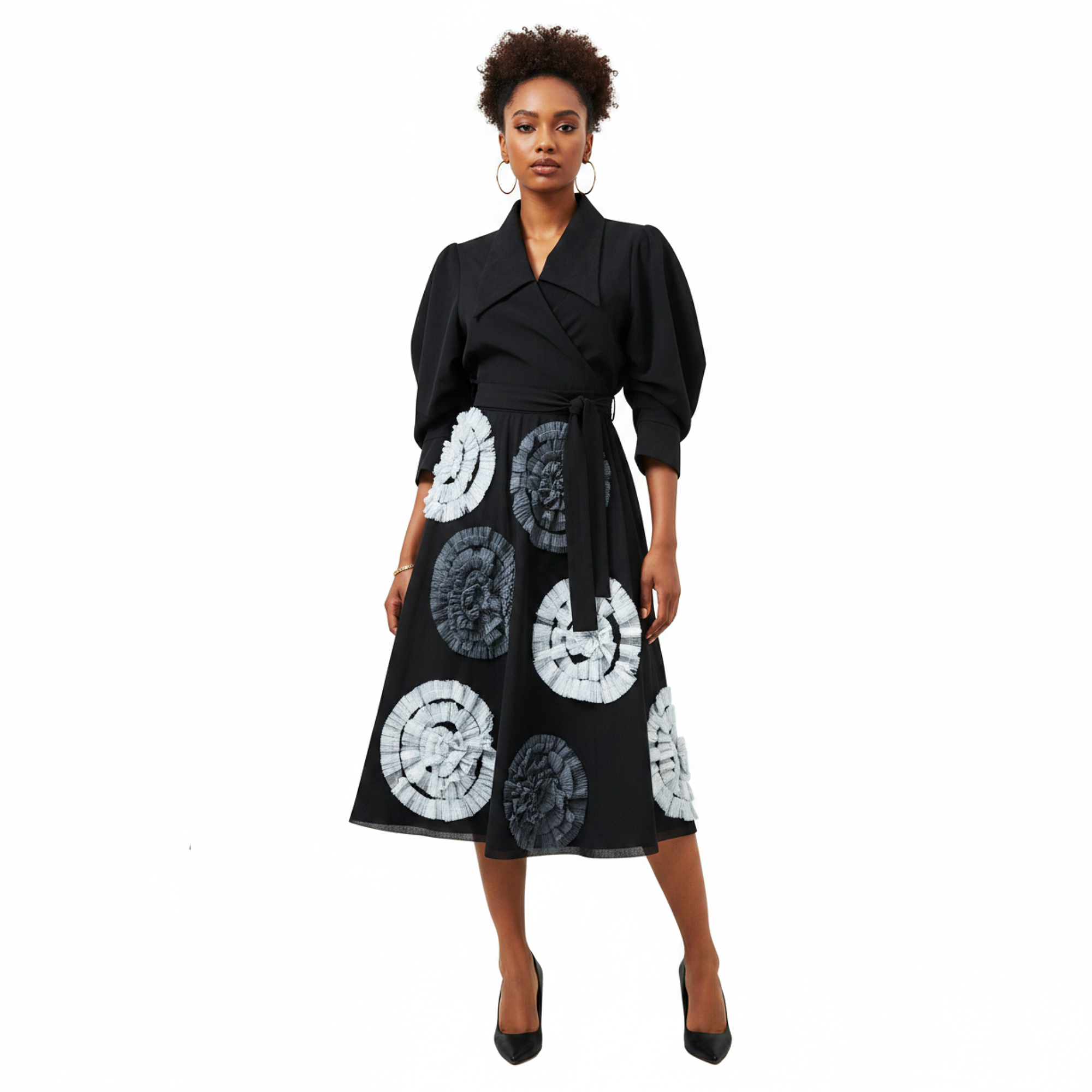 Woman wearing a black dress with white and gray circular patterns on a white background