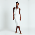 Woman wearing a white sleeveless dress on a plain background
