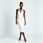 Woman wearing a white sleeveless dress on a plain background