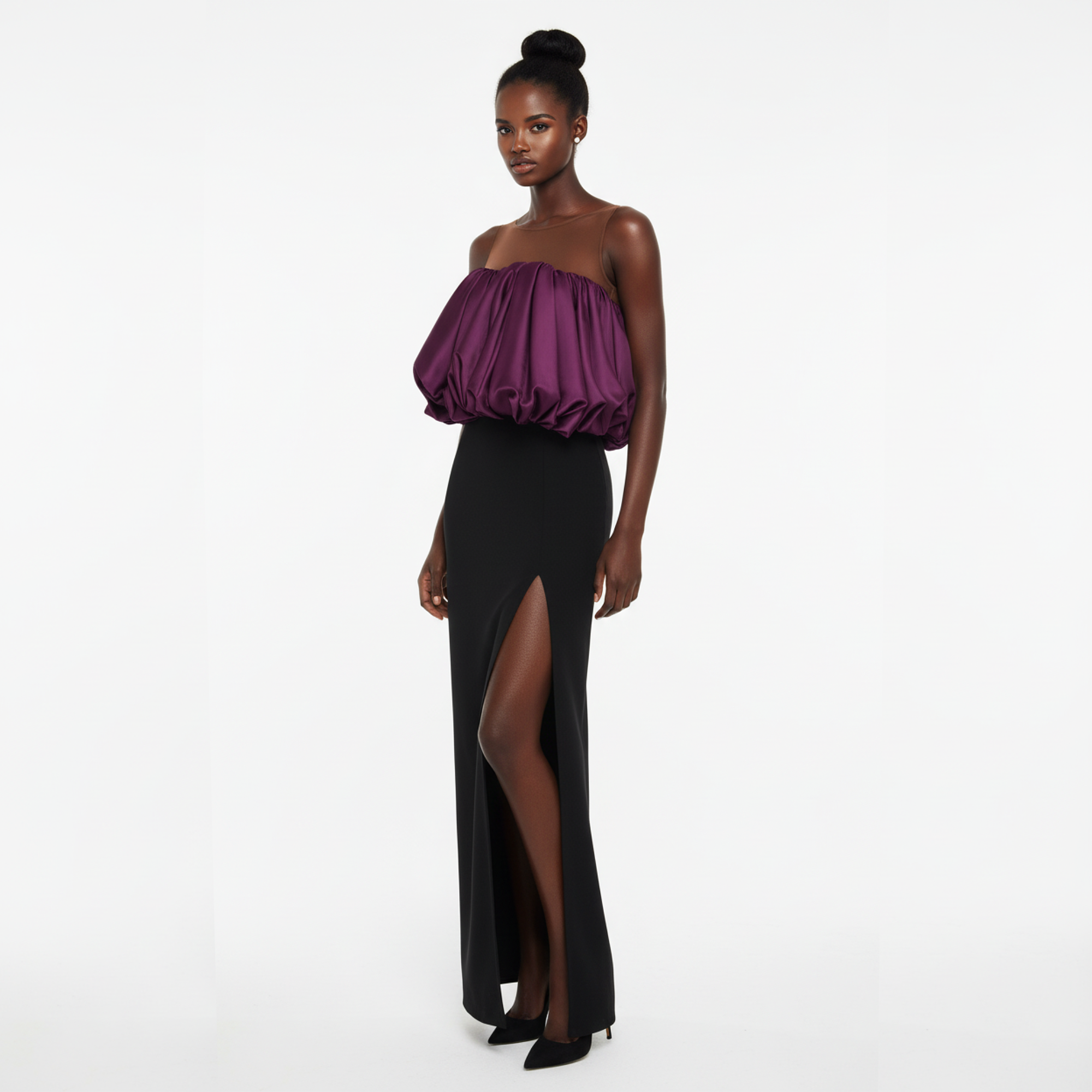 Woman wearing a strapless purple top and black high-slit skirt on a white background