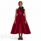 A girl wearing a wine red dress with black bow on a white background