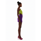 Woman wearing a colorful outfit with a green top and purple skirt on a white background