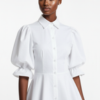 White dress with puff sleeves worn by a model on a white background