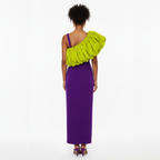 Woman wearing a purple one-shoulder dress with a green ruffled shoulder on a white background