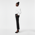 Woman wearing a white blouse and black pants on a white background