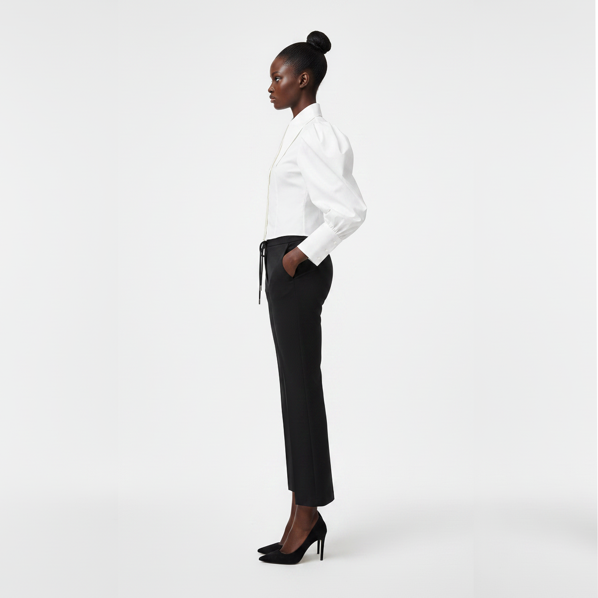 Woman wearing a white blouse and black pants on a white background