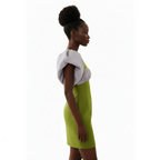 Woman wearing a green dress with a white top on a white background