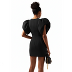 Woman wearing a black dress with puffed sleeves on a white background